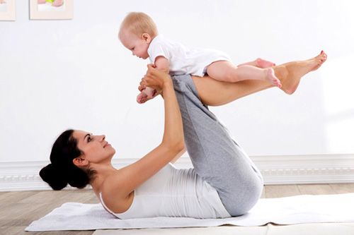 mujer practicando ejercicios de pilates post parto con su bebé 1