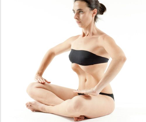 mujer sentada practicando ejercicios hipopresivos beneficios