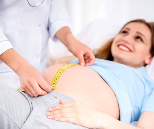 obstetra midiendo la circunferencia del vientre de una mujer embarazada
