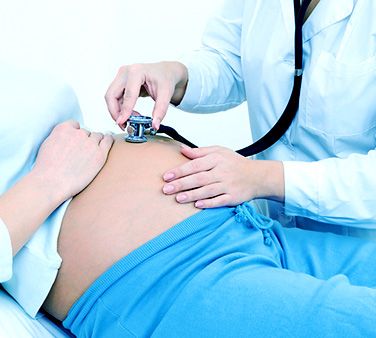 ginecologo escuchando con estetoscopio el vientre de una embarazada tratamiento de problemas ginecológicos